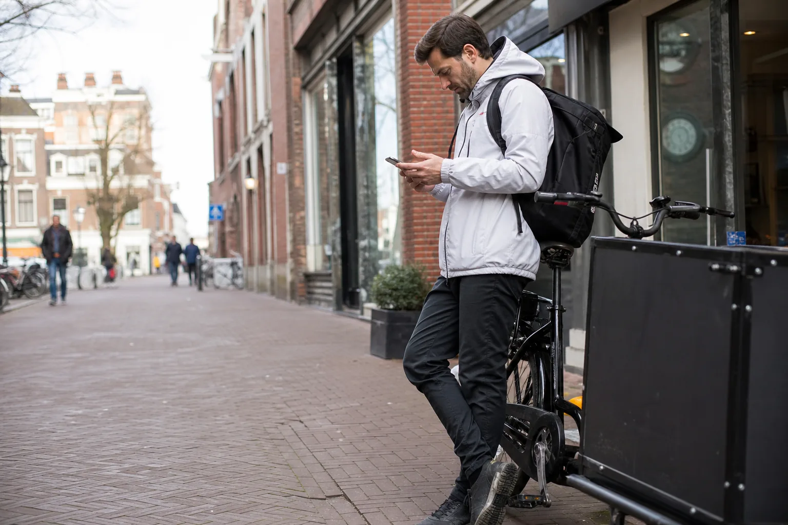 Bike courier checking new gigs on a phone between deliveries