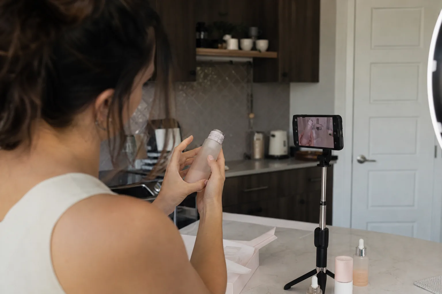 UGC creator filming a skincare product unboxing at a kitchen counter